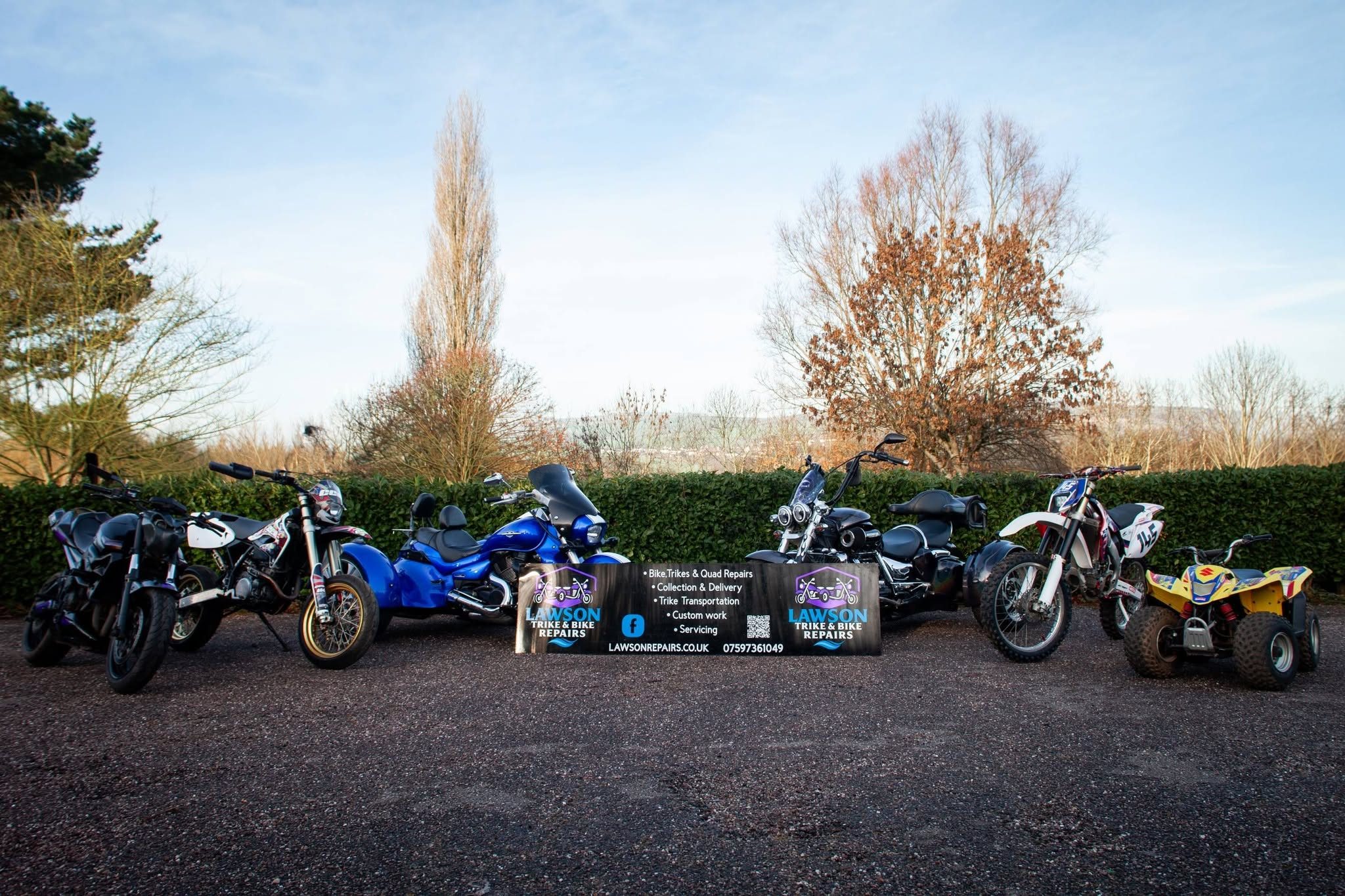 Bikes, trikes and quad bikes lined up with Lawson Repairs branding