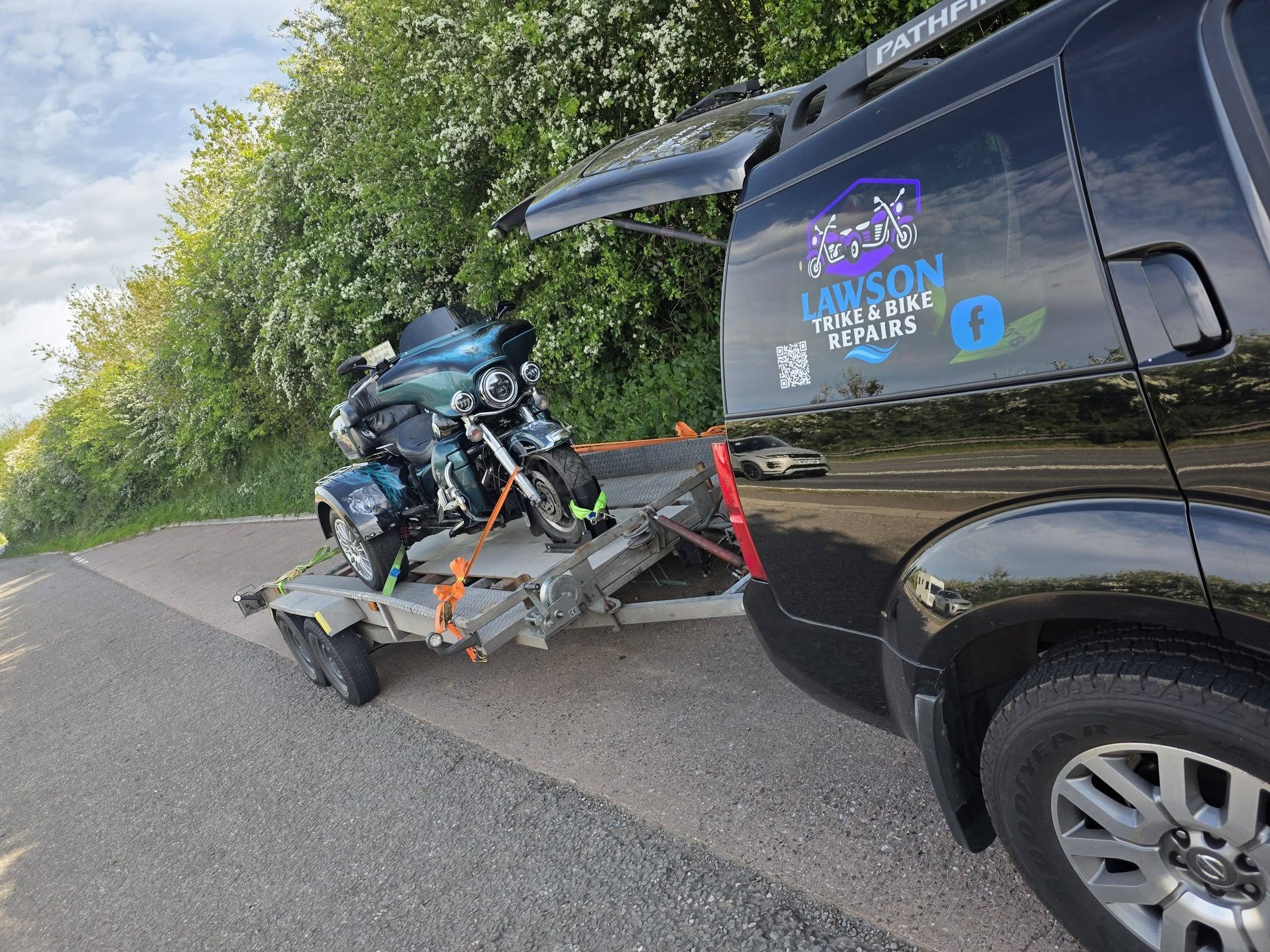 Branded Lawson Repairs van towing a trike on a trailer