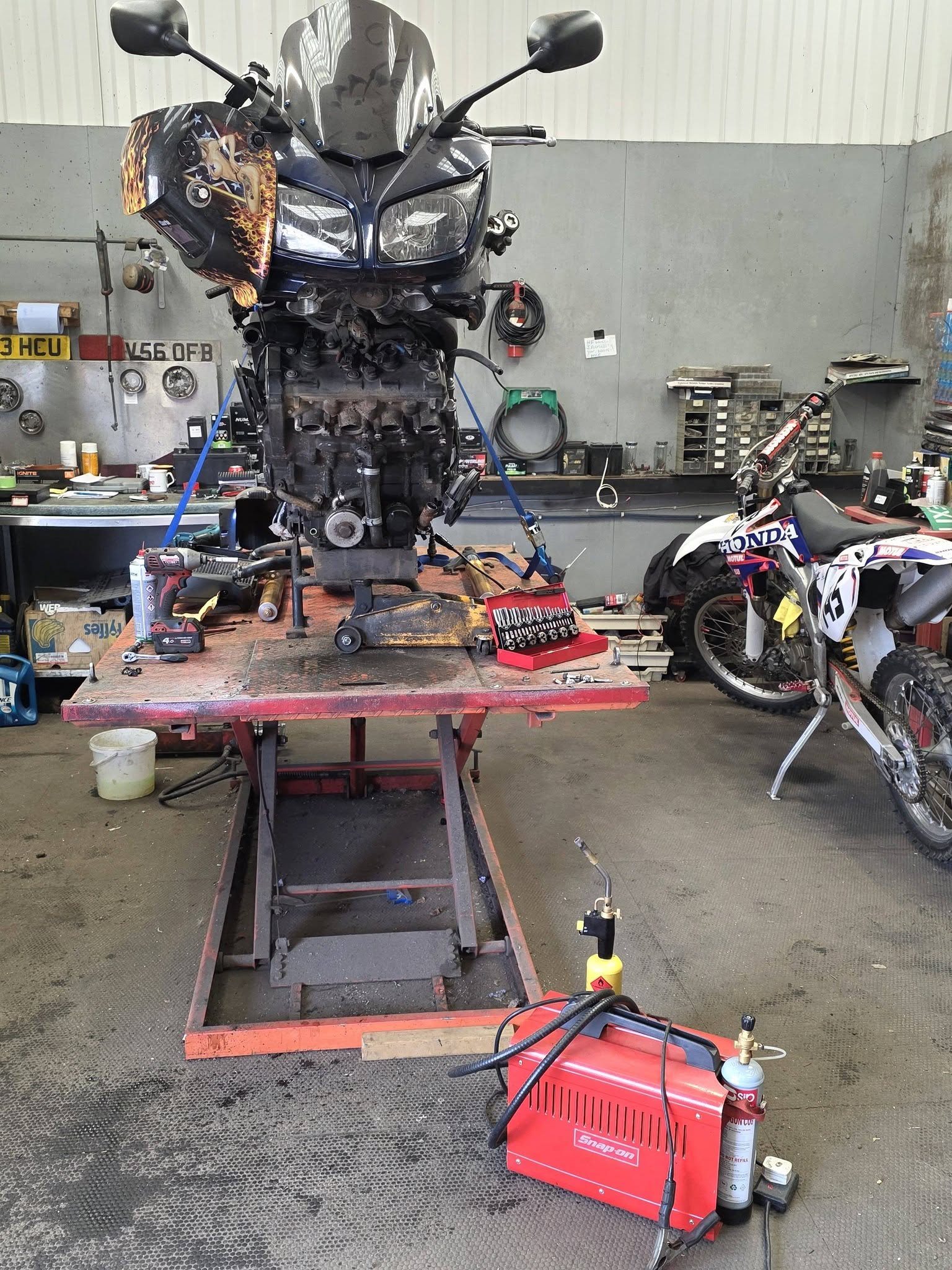 Motorcycle stripped down on a workshop lift for repair